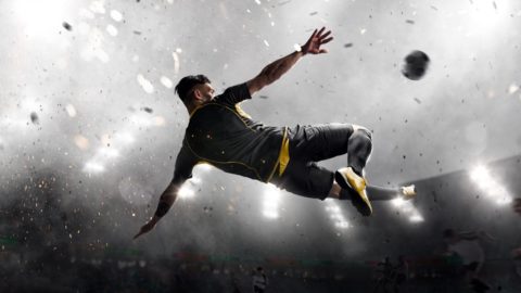 Man jumping to kick soccer ball